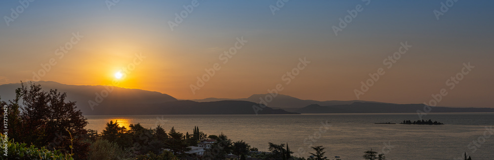 Sunrise in Manerba del Garda with the silhouettes of the mountains in the background on Lake Garda, Italy Sunrise in Manerba del Garda with the silhouettes of the mountains in the background on Lake Garda, Italy