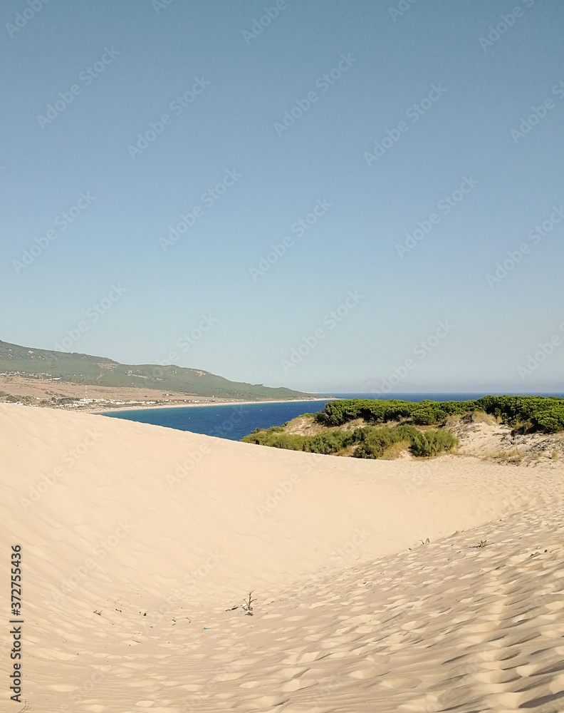 Long shot of a sandy beach behind a dune