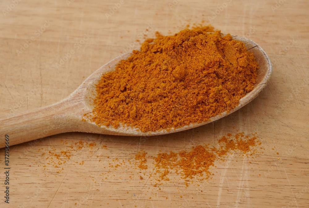 Curry powder on wooden spoon. Indian spice.
Curry powder on wooden spoon. Indian spice.