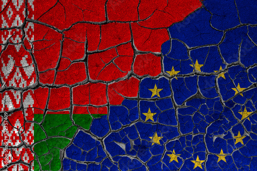 Flags of Belarus and the European Union on a cracked wall, dry land. Concept of relationship or conflict between countries 