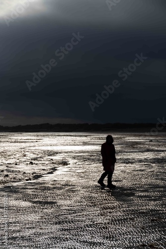 Walking on the beach during a storm when the light breaks through.