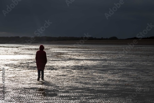 Walking on the beach during a storm when the light breaks through.