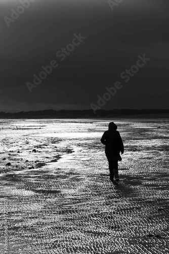 Walking on the beach during a storm when the light breaks through.