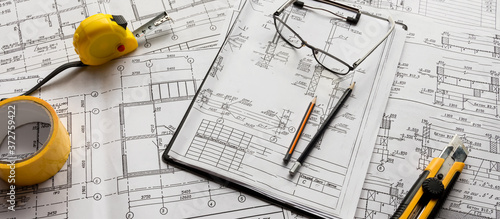 architect design working drawing sketch plans blueprints and making architectural construction model in home.