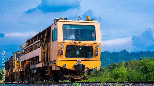 Low angle view of the old orange diesel locomotive on railway against blue sky in natural background