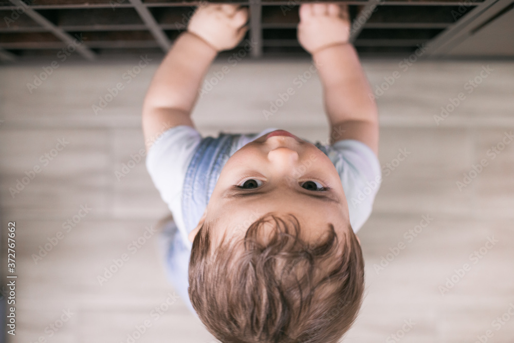Fototapeta premium Baby is crawling around the house and playing and discovering his home playing with his toys 