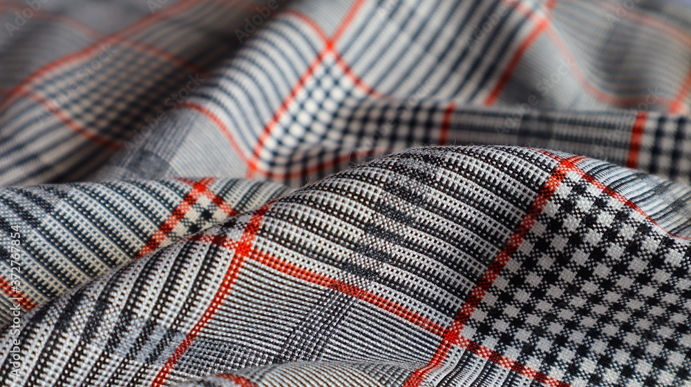 Textile gray plaid fabric with red lines close-up Textile gray plaid fabric with red lines close-up