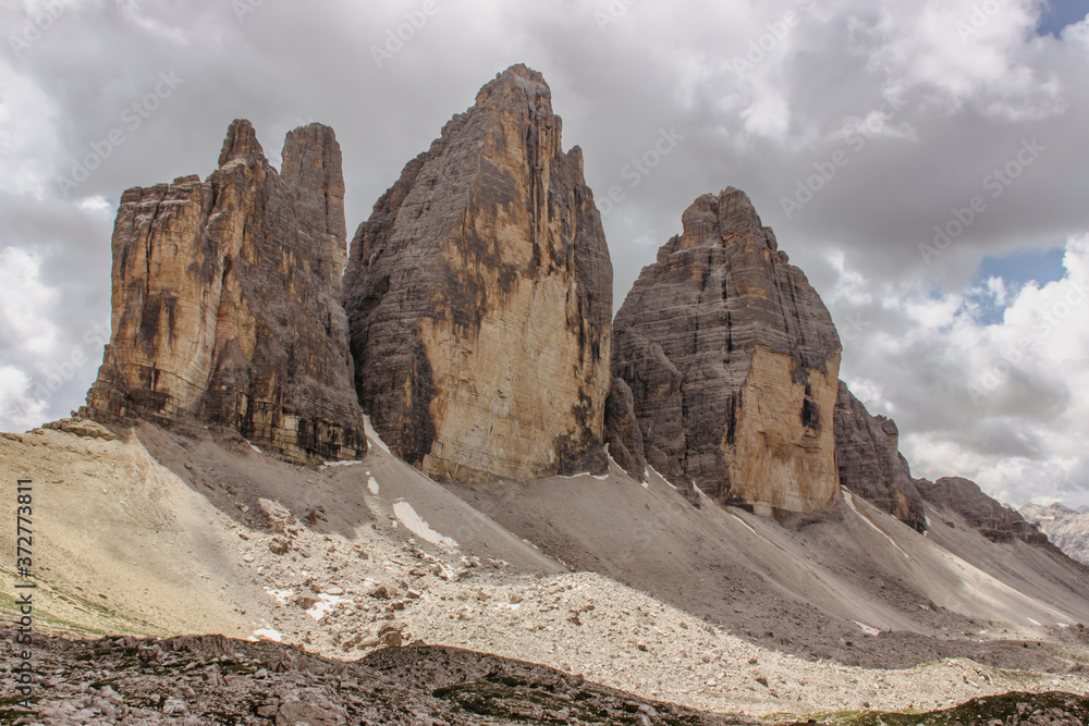 Hiking around three peaks of Tre Cime di Lavaredo (Drei Zinnen), Dolomites, Italy. One of the best-known mountain groups in the Alps. Active healthy lifestyle. Beautiful view of high rocky mountains.