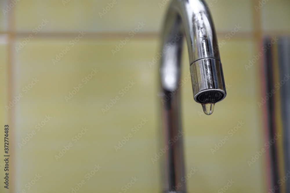 The crane is leaking. a drop of water drains from the tap. leaking plumbing. The crane is leaking. a drop of water drains from the tap. leaking plumbing.