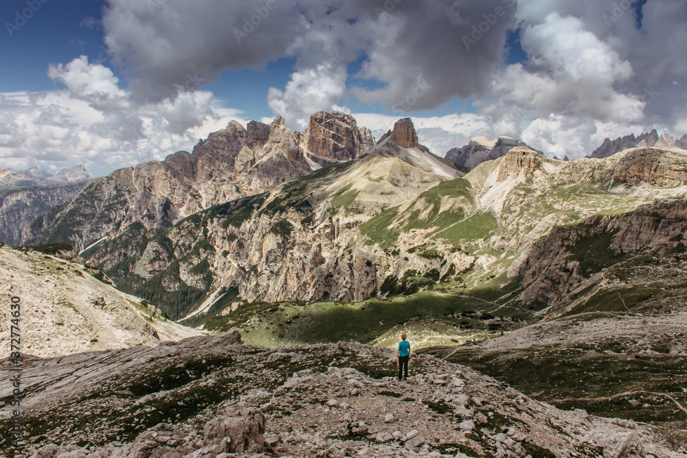 Girl enjoying an amazing view of the mountains. Italien Dolomites. Hiking day. Lonely woman. Active lifestyle. Female hiker in the mountains.Copy space for text travel agency.European summer vacation