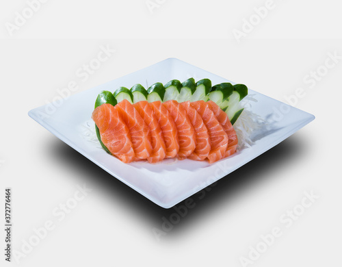 slices of salmon sashimi, served on a white plate. isolated