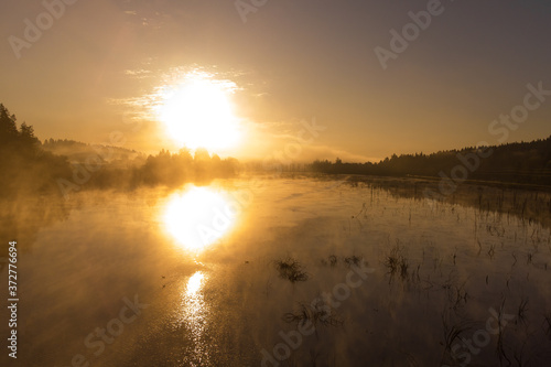 Sunrise or sunset on the lake with fog and steam