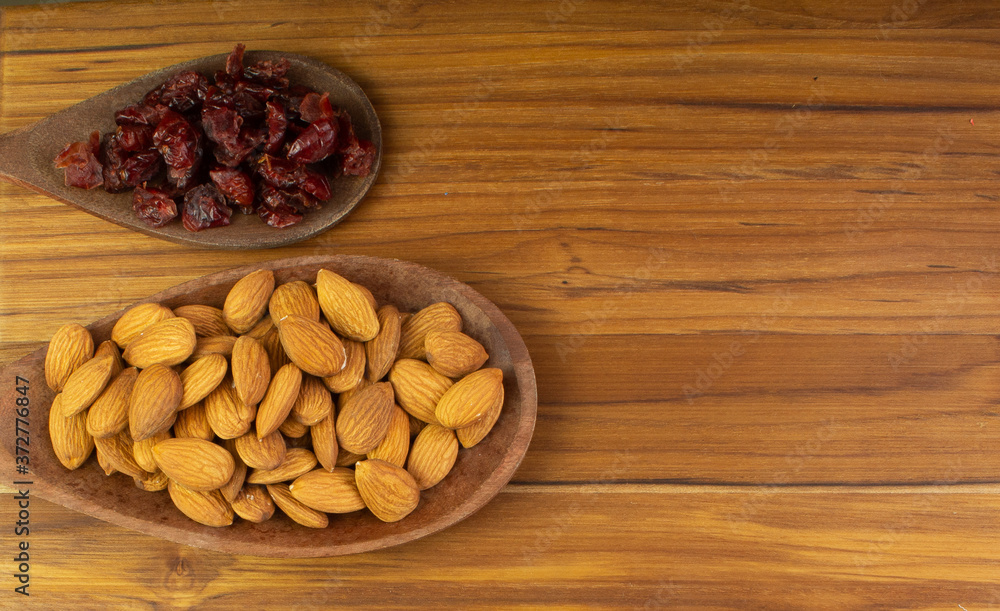 two spoons full of craberries and almonds two spoons full of craberries and almonds