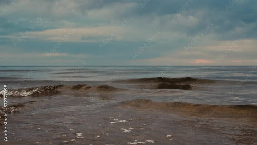 Beautiful sunset by the sea with clouds and small waves Beautiful sunset by the sea with clouds and small waves
