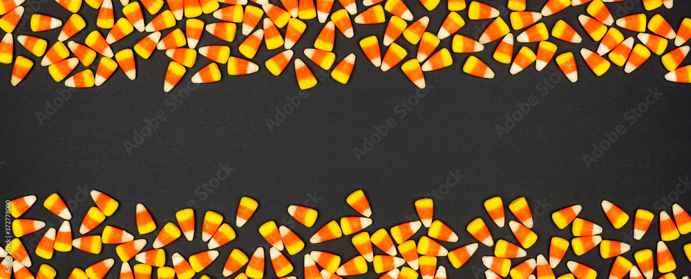 Halloween candy corn double border banner. Top view on a black background with copy space.