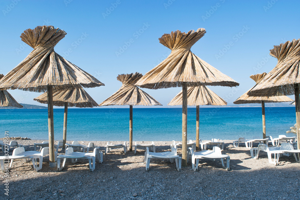 Sandstrand mit Liegestühlen uns Sonnenschirmen in Kroatien (Punat/Krk)