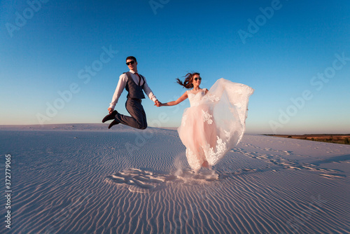 Canvas Print the bride and groom on the beach at sunset