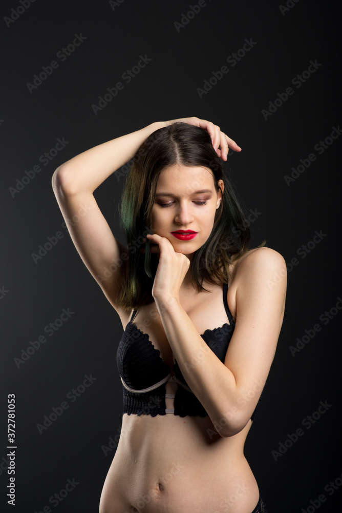 Vertical view photo beautiful shy lady in lace bikini boudoir bra panties. Tender skinny slim shape isolated black background.