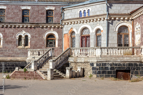 An old open outer stone staircase. Stone, cement steps of the old staircase with traces of weathering and destruction. An ancient stone staircase, ancient broken worn steps. Selective focus