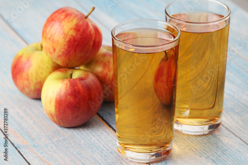 Glasses with apple juice and ripe apples 