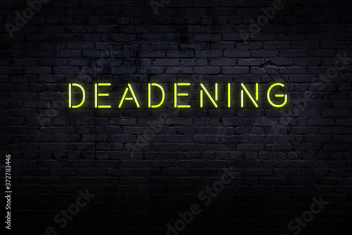 Night view of neon sign on brick wall with inscription deadening photo