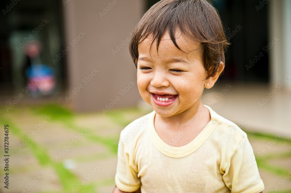 .Girl smiling and having fun with the water splashing from the hose. Summer joke. Happy child. Selective focus .Girl smiling and having fun with the water splashing from the hose. Summer joke. Happy child. Selective focus