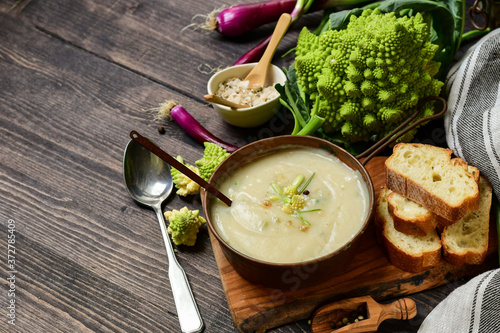 Romanesco cabbage or broccoli cream soup . cauliflower  soup on a wooden table.  fall seasonal menu.  photo