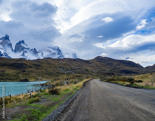 Beautiful unpaved road flanked by a lake on the way to Parque National Torres del Paine. Patagonia, Chile.