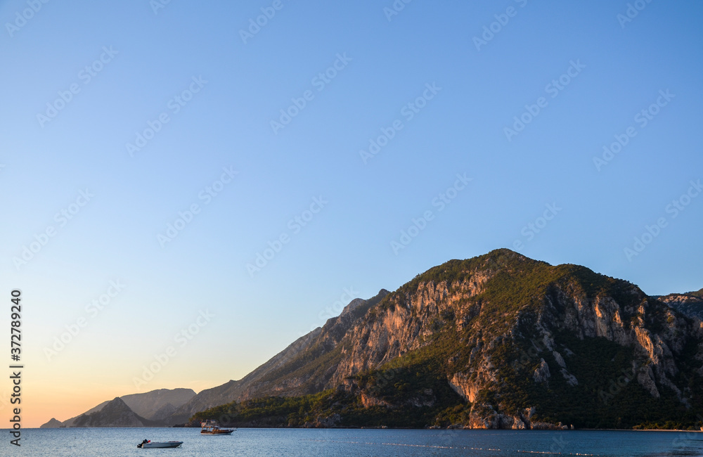 Beautiful orange sunrise on the Mediterranean Sea shore at Olympos coast, Cirali village, Turkey