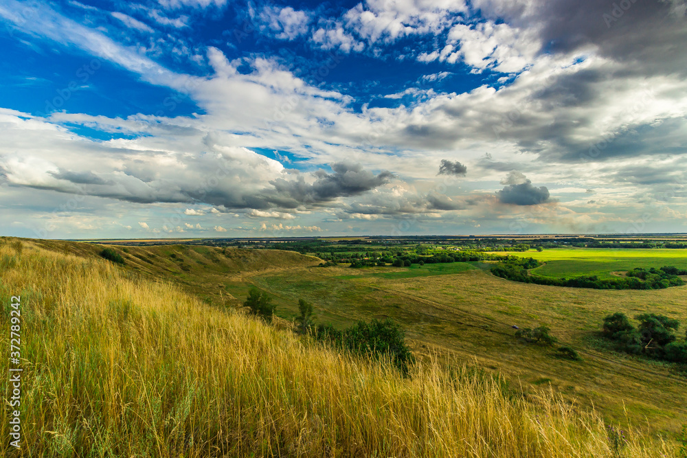 Obraz premium landscape photos of hills under clouds blue sky and green grass