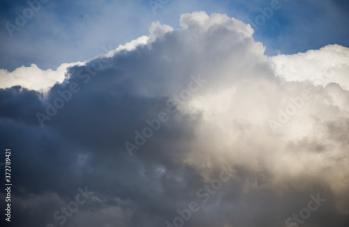 Fluffy clouds cover the summer blue sky