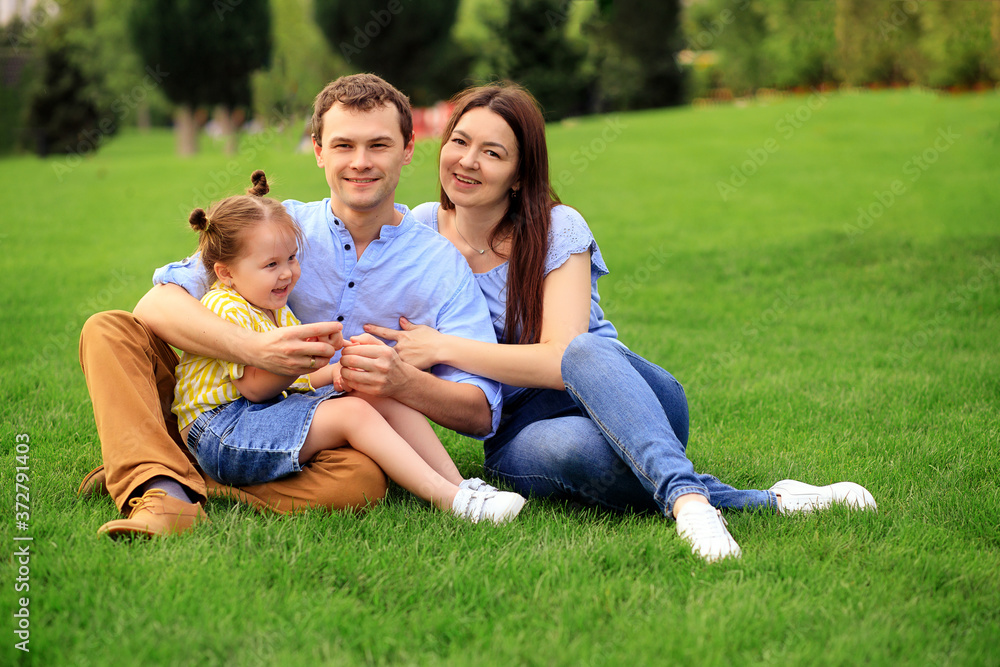 Portrait of a happy family in the summer outdoors in the park