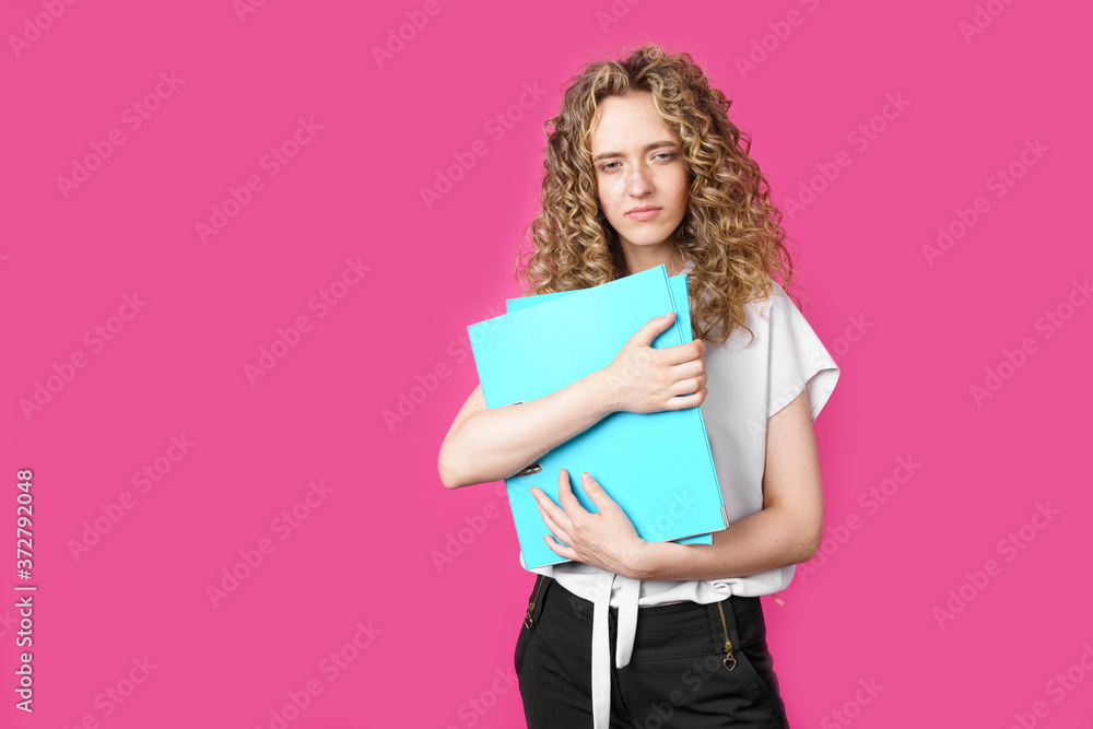 A young woman holds folders with documents in her hands. A young woman holds folders with documents in her hands.