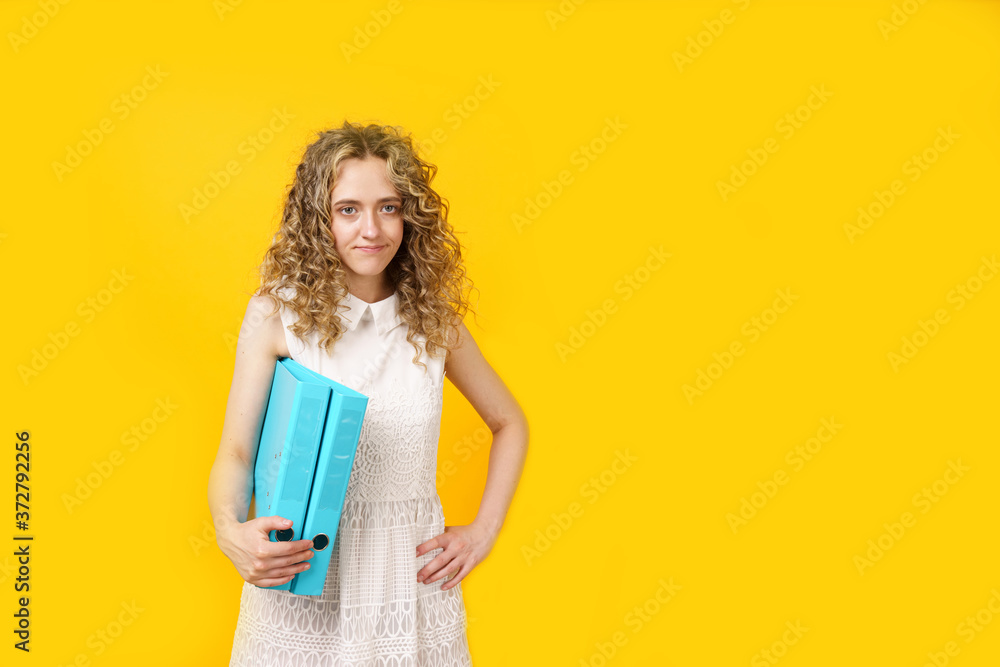 A young woman holds folders with documents in her hands. A young woman holds folders with documents in her hands.