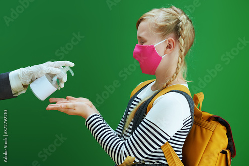 modern female teacher and pupil disinfecting hands