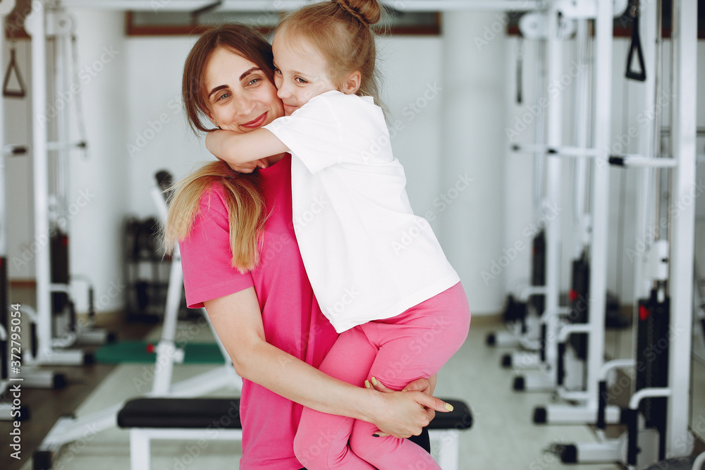 Mother with daughter in a gym. Little girl are engaged in gymnastics Mother with daughter in a gym. Little girl are engaged in gymnastics