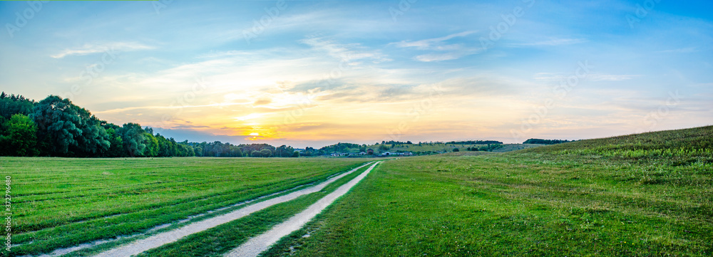 wide panorama with sunset over the field 