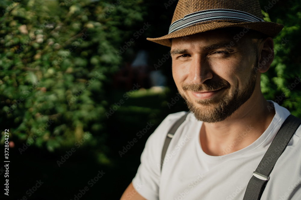 happy gardener young European man . the background of green trees