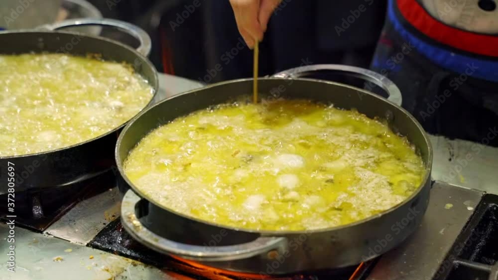 Chef cooking Chinese seafood pancake thoroughly using wooden stick Chef cooking Chinese seafood pancake thoroughly using wooden stick