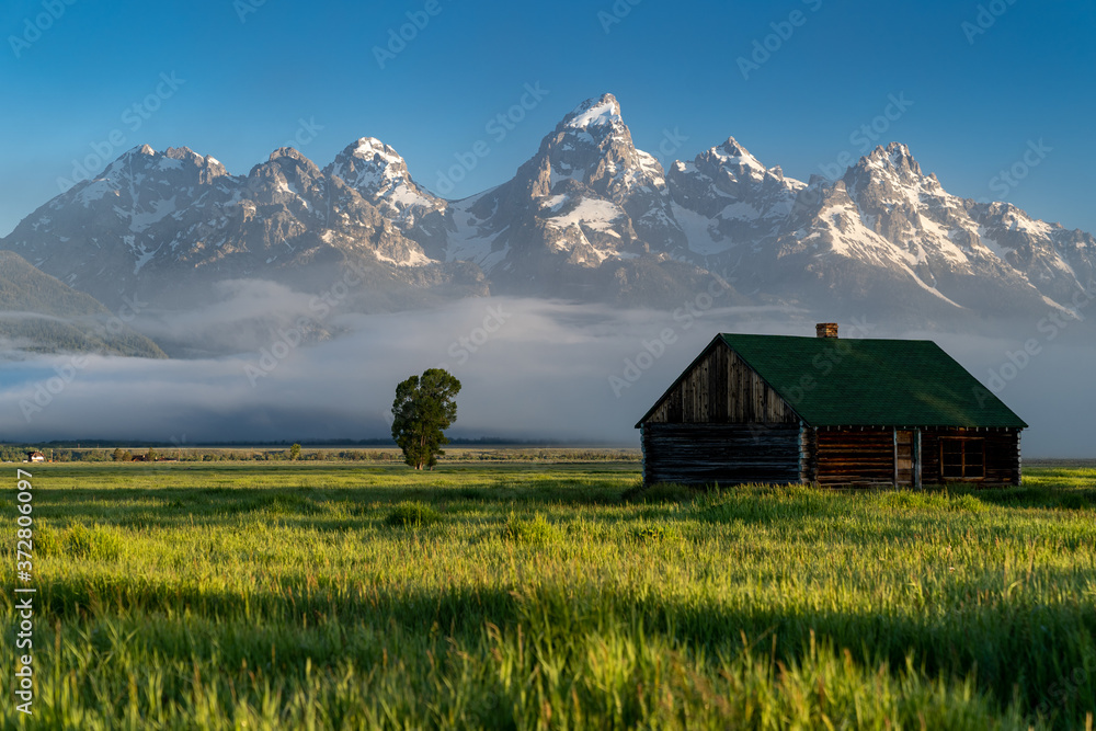 Obraz premium Rustic building, part of the historic Morman Row homestead in Antelope Flats, in Grand Teton National Park Wyoming, at sunrise