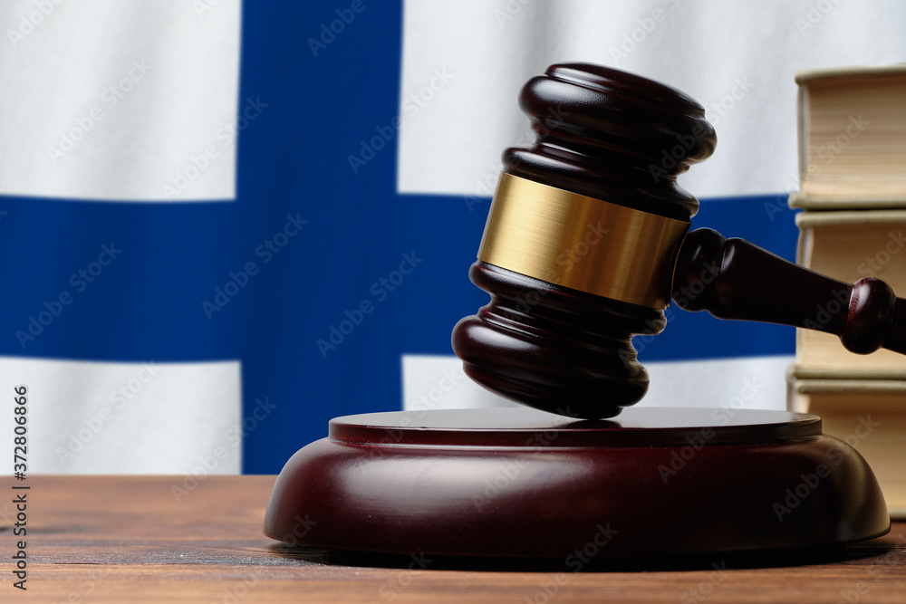 Justice and court concept in Republic of Finland. Judge hammer on a flag background