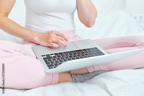 A girl prints on a laptop keyboard.