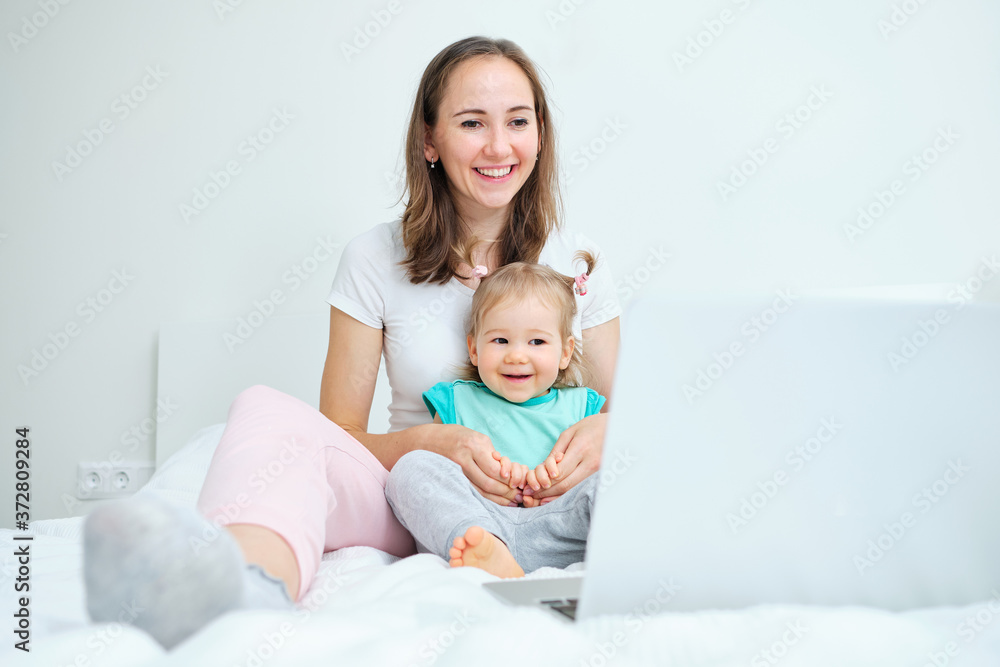 Toddler and Mom sitting on the roof of the house looking at the laptop. Toddler and Mom sitting on the roof of the house looking at the laptop.