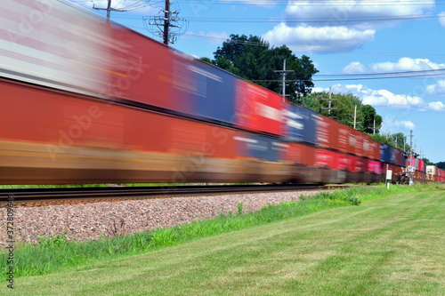A speeding intermodal freight train is a blur as it speeds through Geneva, Illinois a western suburb of Chicago. The fast intermodal freight was westbound from Chicago destined for points west.