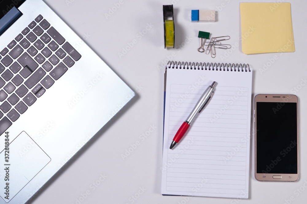 Modern white office desk table with laptop, smartphone and other supplies. Modern white office desk table with laptop, smartphone and other supplies.