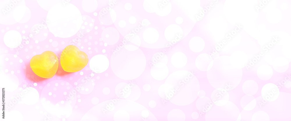 yellow lollipops shape hearts, pink decorative bokeh background, concept for valentines day Love day Banners for websites Computer screen And beautiful design