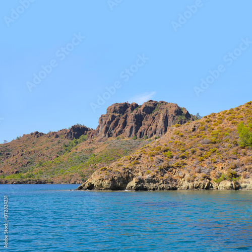 Seascape. Blue sea and rocky shores. Square format.