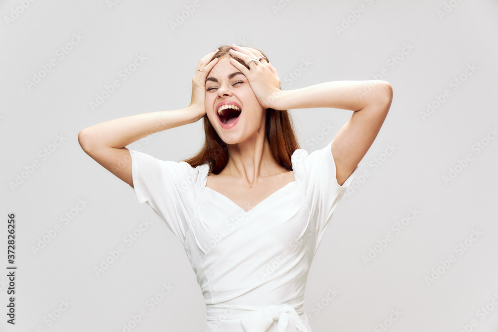 women holding her head wide smile closed eyes joy white dress cropped