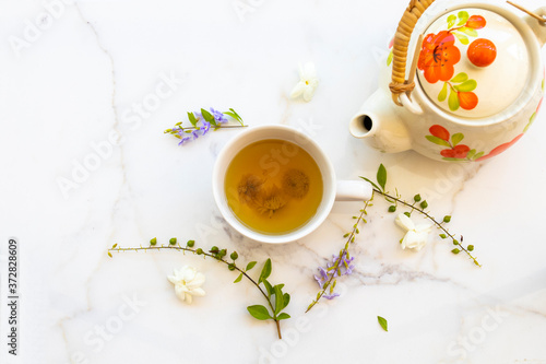 herbal healthy drinks hot chrysanthemum tea local flora of asia with teapot, flower jasmine ,purple in summer season arrangement flat lay style on background white 