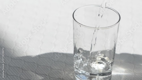 グラスに水を注ぐ様子。水を飲む。